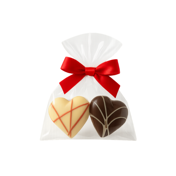 Himeerherzpraline und Nougatherzpraline in einer Tuete mit Schleife